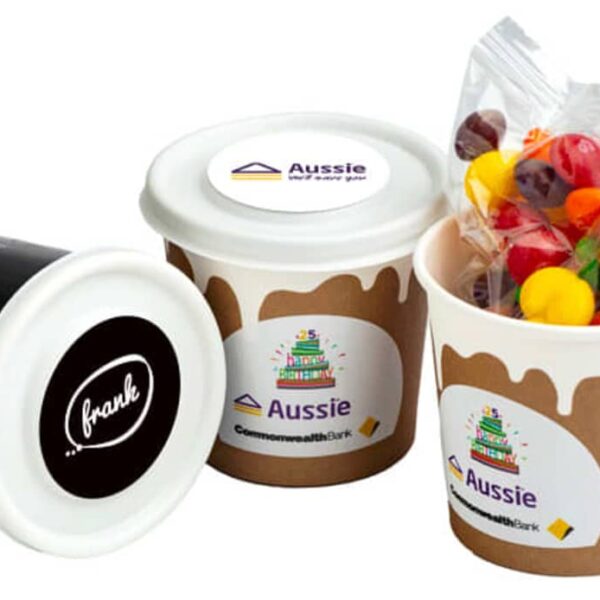 Three branded cups, one tipped over, one open with candy, all with company logos visible.
