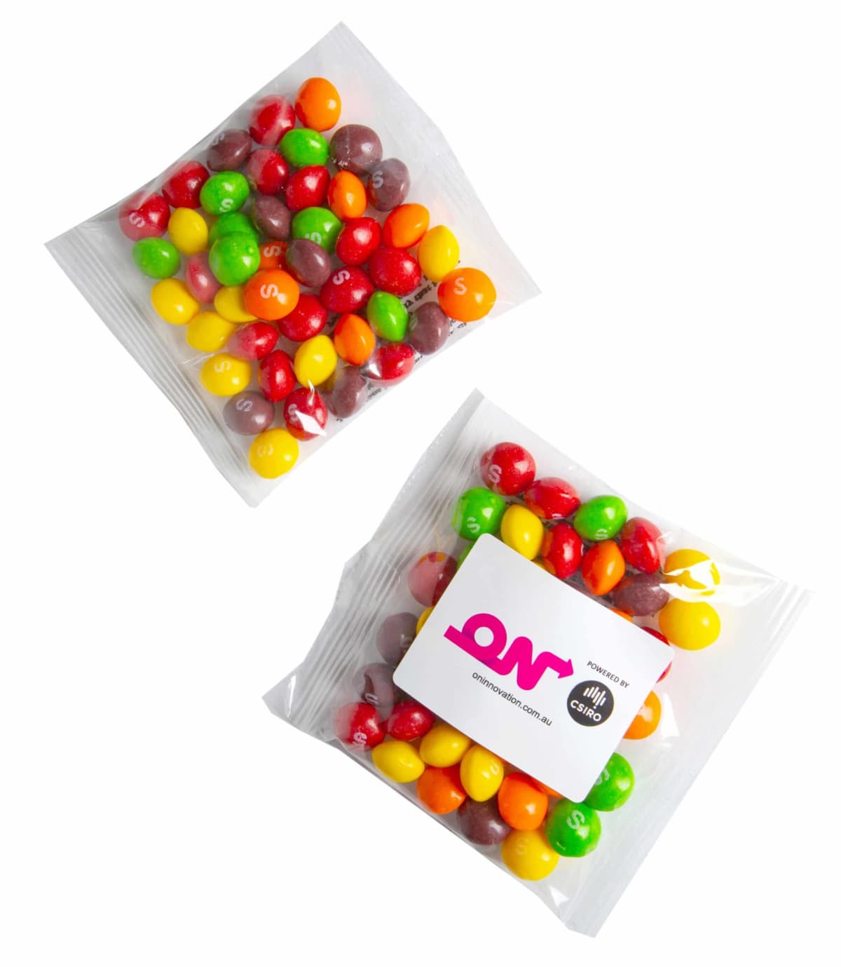 Two clear bags of colorful Skittles candy, one with a white logo label on the front.