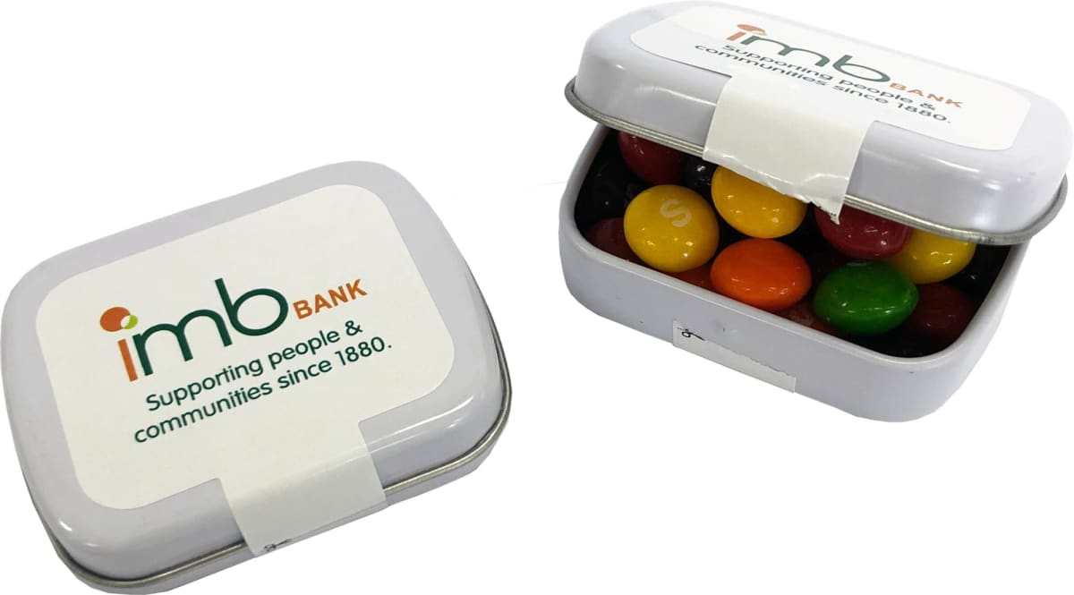 Two tins labeled IMB BANK filled with colorful candy-coated chocolates.