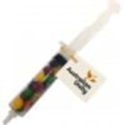 A syringe-shaped container filled with colorful jelly beans and a tag that says Australian Lolly.