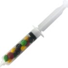 A plastic syringe filled with colorful candy-coated chocolates.