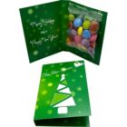 Green holiday card with tree design, open to show a candy pouch and festive greeting inside.