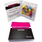 Black card with MONSTER HIRE, open to reveal candy and a welcome message inside.
