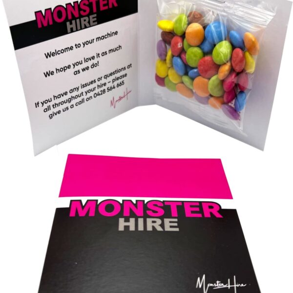 Greeting card with MONSTER HIRE text and a packet of colorful candy inside.