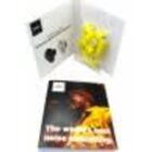 Open magazine with a yellow bow and headphones, showing a person on the cover.