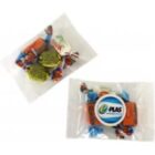 Two small clear bags containing assorted colorful candies and a round branded mint container.
