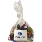 A clear bag of assorted candies with a Zurich logo label on the front.