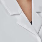 Close-up of a person wearing a white lab coat with a collar and button detail.
