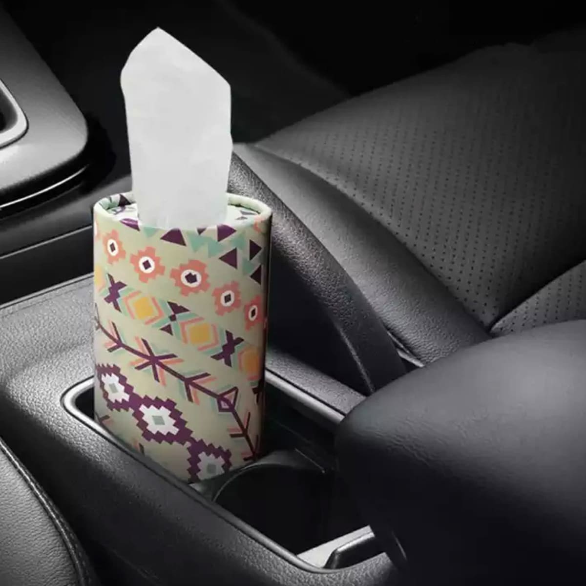 Geometric-patterned tissue box in car cup holder.