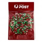 A cookie with red, green, and white sprinkles in Australia Post packaging.