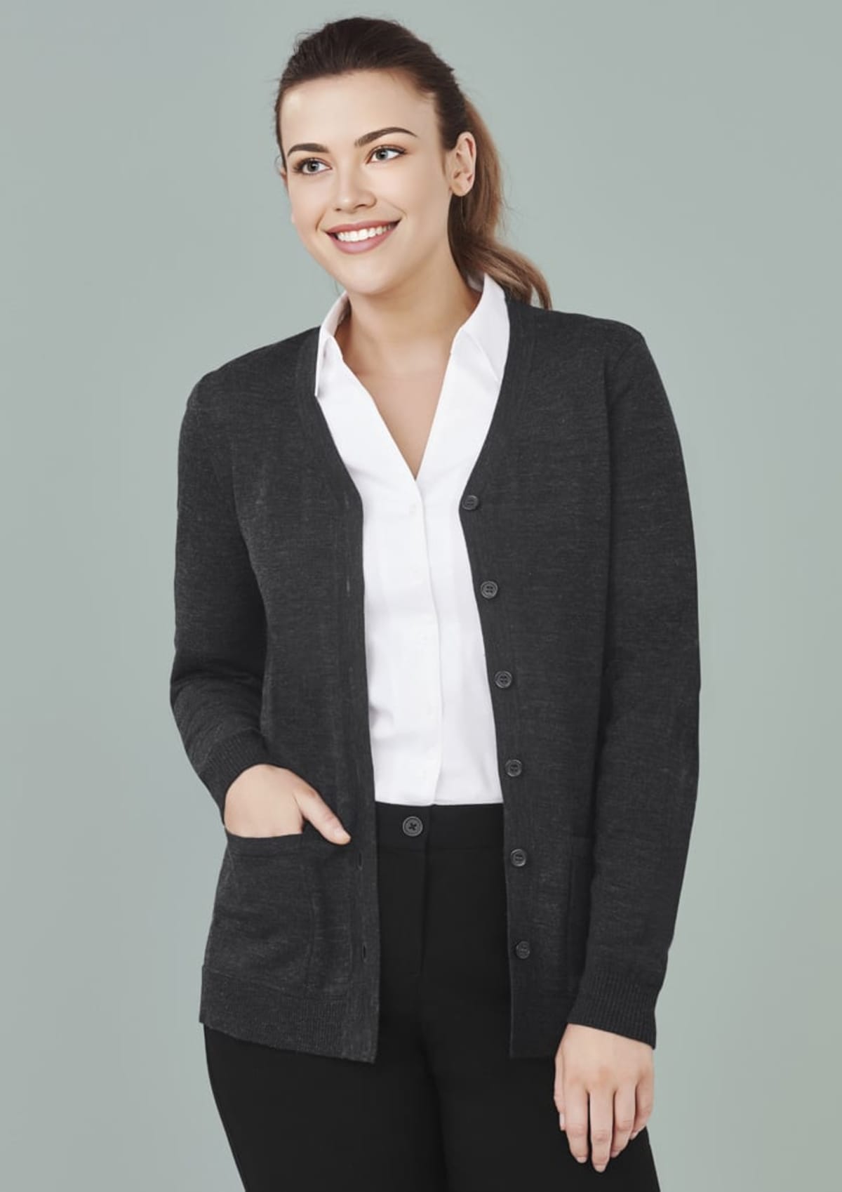 A person in a dark sweater smiles against a plain background.