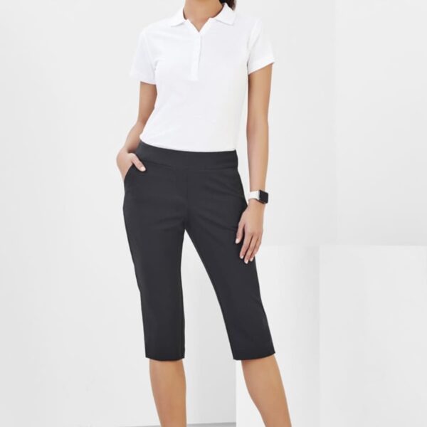 Person in white shirt and black capris poses against a white background.