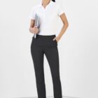 Smiling person in a white polo shirt and black pants holds a notebook against a white background.