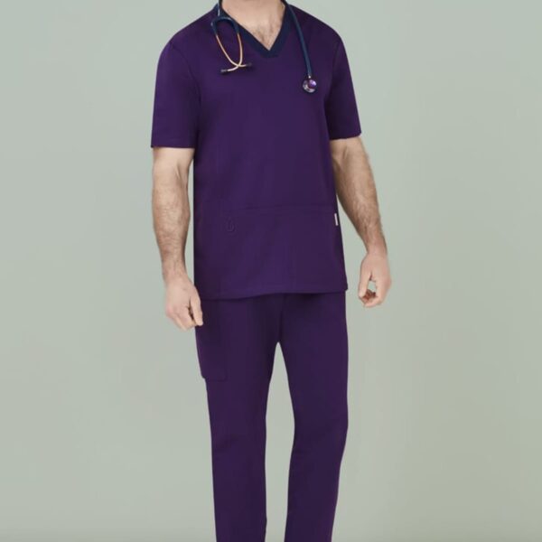 Person in purple scrubs with a stethoscope around their neck, standing against a neutral backdrop.