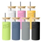 Seven colorful tumblers with bamboo lids and metal straws.