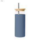 Blue tumbler with wooden lid and metal straw on a white background.