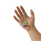 Hand holding a colorful pyramid-shaped keychain with a flower pattern.