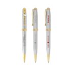 Three silver and gold ballpoint pens with different logos printed on their barrels.