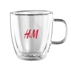 Clear glass mug with H&M in red lettering.