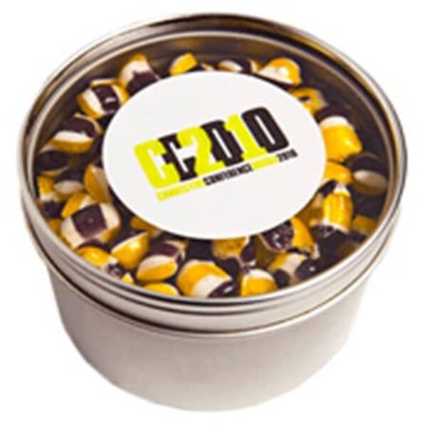 A metal tin filled with yellow, black, and white striped hard candies.