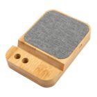 Wood and fabric charging station with slots for cables and a device.