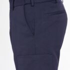 Side view of a person wearing navy blue pants with a pocket, and a green shirt.