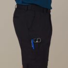 Person wearing black shorts with pockets holding a pen and glasses.
