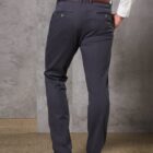Rear view of a person in gray pants, brown belt, white shirt, and brown shoes.