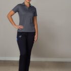 Person in gray polo and black pants stands on polished concrete floor.