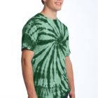 Person in a green tie-dye shirt smiling against a light background.