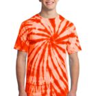 Person wearing an orange and white tie-dye shirt, smiling, standing against a plain background.