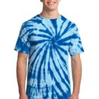 Smiling person in a blue tie-dye t-shirt and jeans against a plain background.