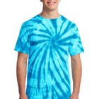 Person in blue tie-dye shirt smiling, wearing jeans against a white background.
