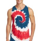 Man wearing a red, white, and blue tie-dye tank top and jeans smiles at the camera.