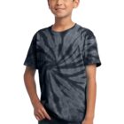 Boy in a black tie-dye shirt and jeans posing casually, smiling.