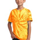 Child wearing an orange tie-dye shirt and jeans, smiling at the camera.