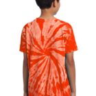 Boy in an orange tie-dye shirt standing with his back to the camera.