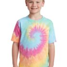 Child wearing a colorful tie-dye shirt, smiling, with hands by sides.