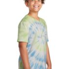 Smiling child wearing a green and blue tie-dye shirt, standing sideways.