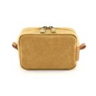Small tan toiletry bag with dual zipper and side handles, viewed from the front.