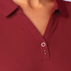 Close-up of a person wearing a maroon collared shirt with buttons undone at the top.