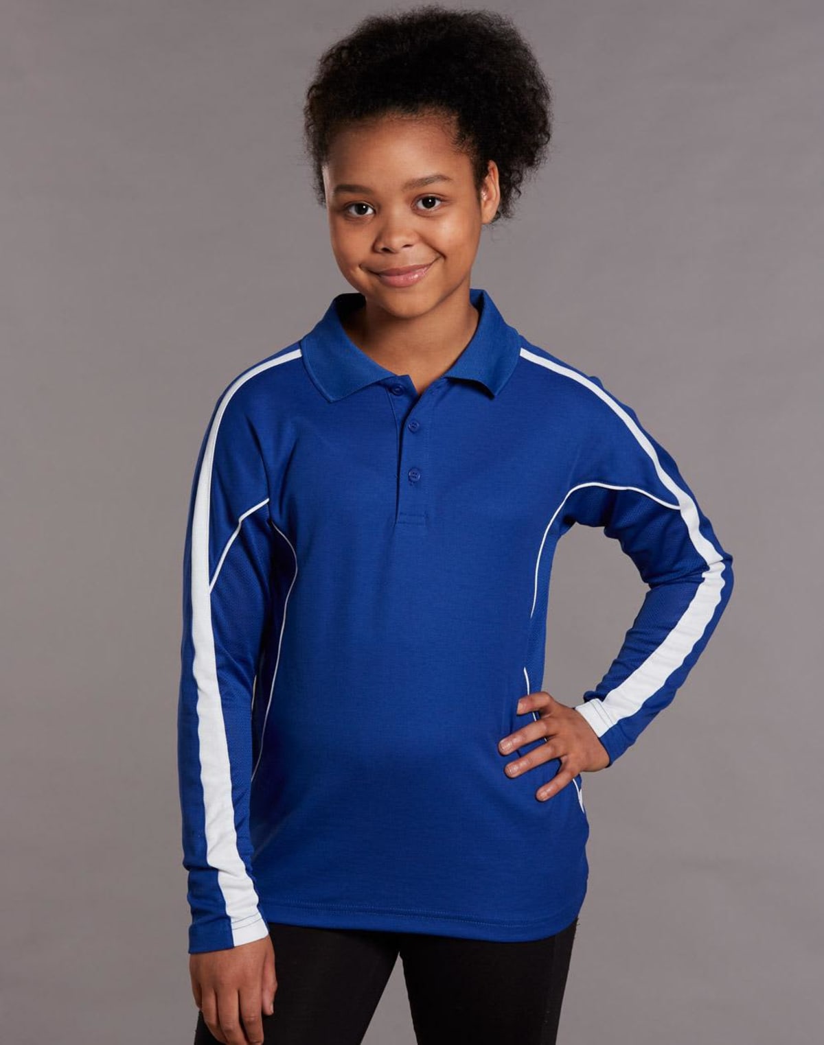 Young girl in a blue and white-striped long-sleeve polo shirt, smiling with one hand on hip.