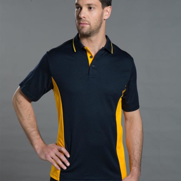 Man in a black and yellow polo shirt poses against a gray backdrop.