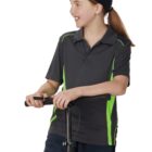 Girl in black cap and sportswear holding a scooter handle, looking to her left.