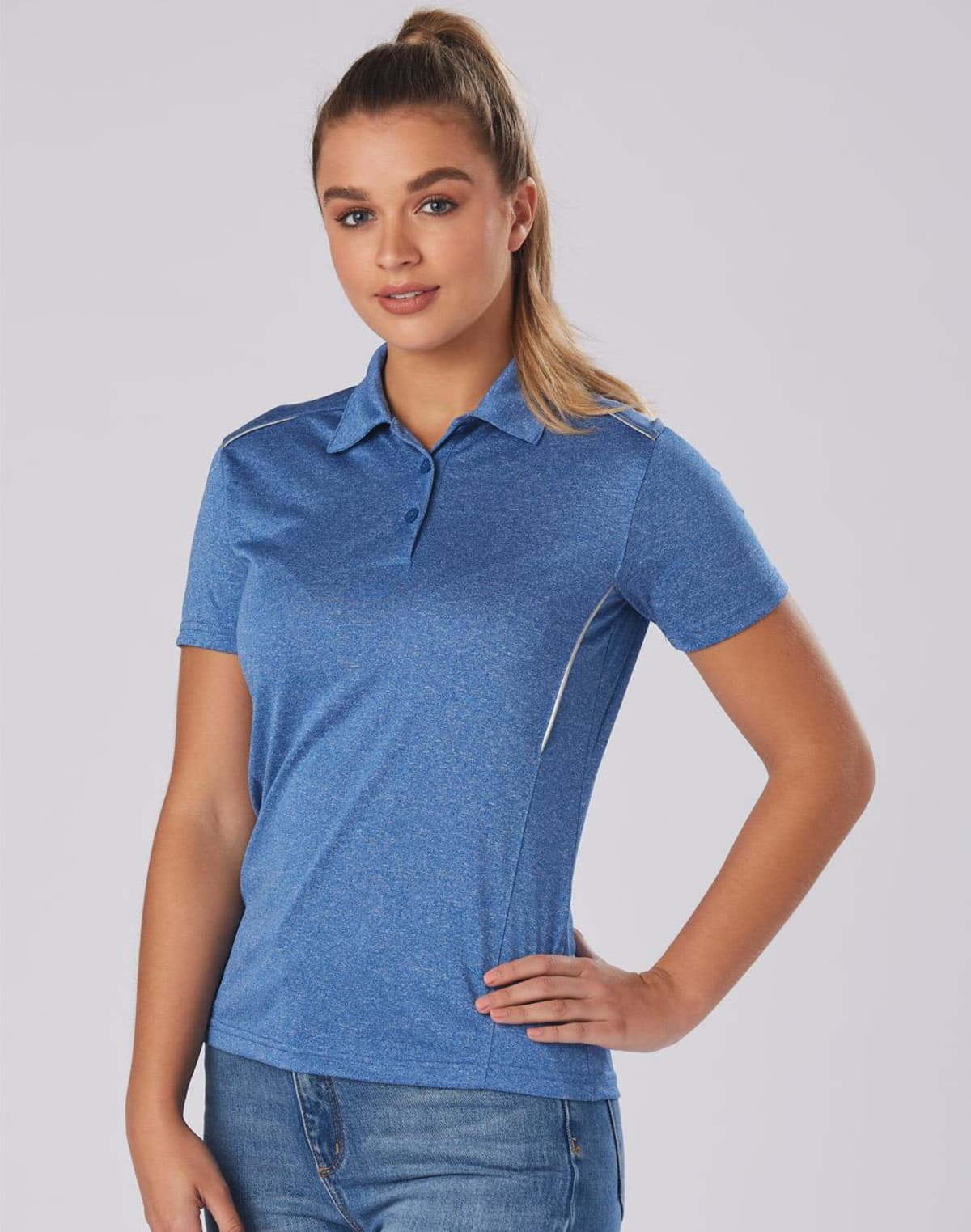 Person in a blue polo shirt and jeans poses against a plain background.