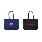 Two reusable tote bags, one navy with a university logo, one black with a Cinemex logo.