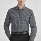 Person wearing a black and white checkered shirt and black pants against a white background.