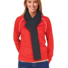 Person smiling in a red top with a dark scarf, hands in pockets.
