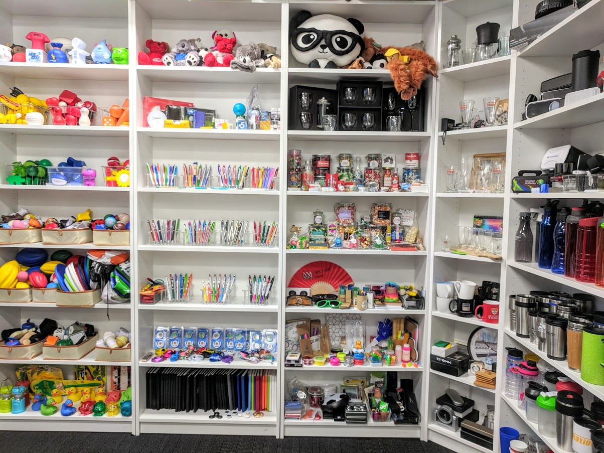 Shelves of promotional items filled with pens stressballs and other merchandise