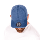 Person in white shirt wearing a blue cap with HYDRO patch, head tilted downward.